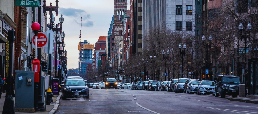cars parked on a street with one car driving towards us
